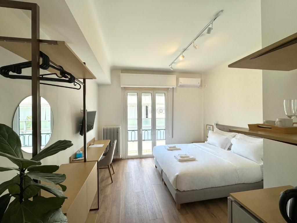 Voulis Best Global Home في أثينا: غرفة نوم بسرير ابيض كبير وطاولة