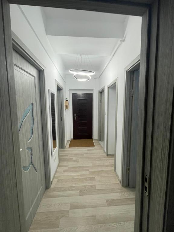 pasillo de un pasillo con paredes blancas y suelo de madera en E&N ACCOMMODATION, en Bacău