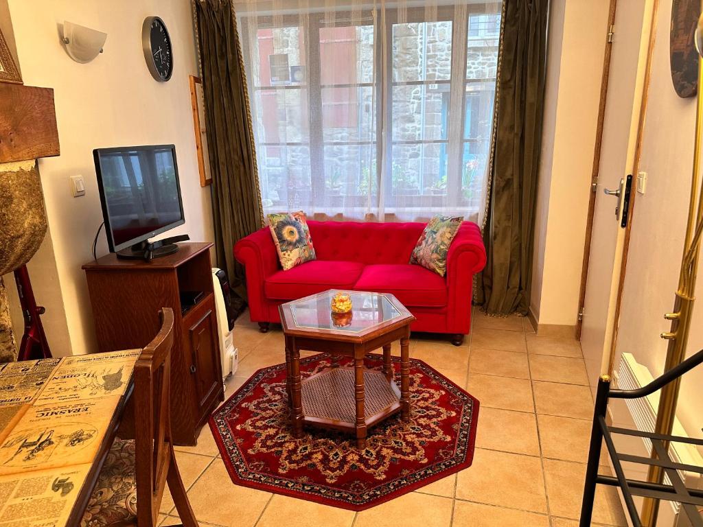 sala de estar con sofá rojo y TV en Ker Viviane, en Dinan