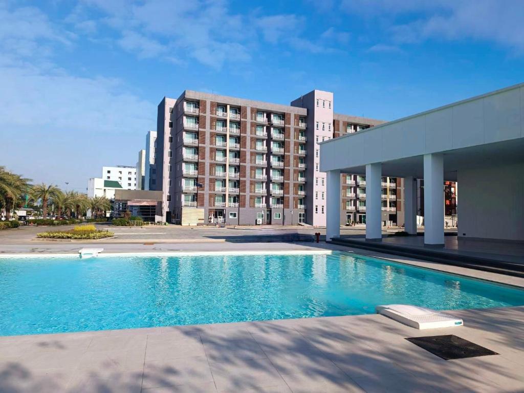 uma grande piscina em frente a um edifício em TM Land Hotel em Phra Nakhon Si Ayutthaya