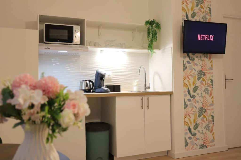 a kitchen with a vase of flowers and a microwave at LP - 4 saisons in Annecy