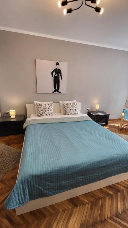 1 dormitorio con 1 cama grande y edredón azul en Casa Corona, en Brasov