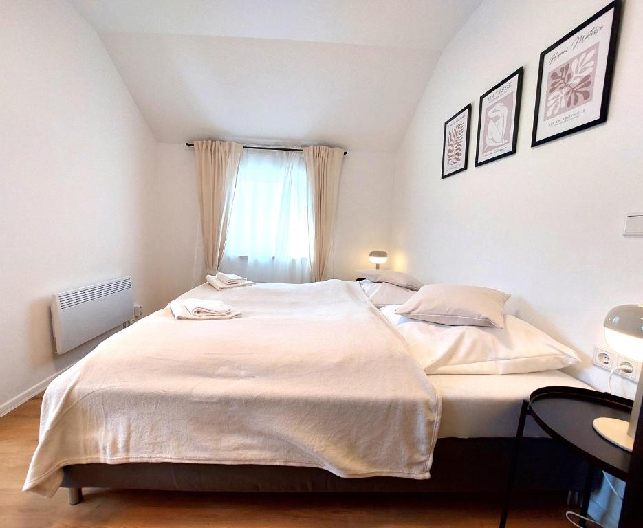 a bedroom with a large white bed with a window at Airport-Messe Apartments in Düsseldorf