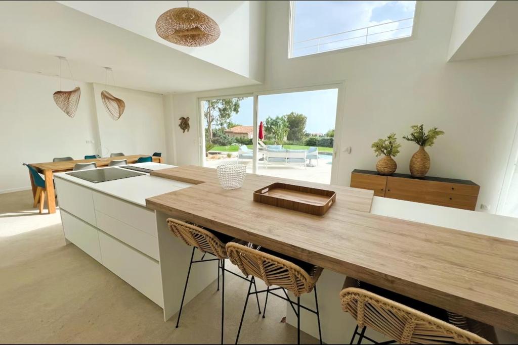 a kitchen with a large wooden table and chairs at Villa d'exception piscine privée et vue mer in Saint-Cyr-sur-Mer