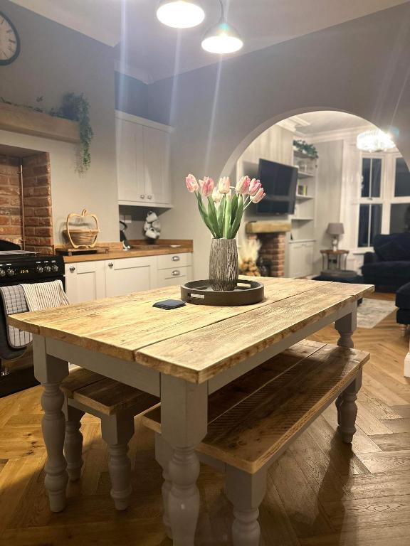 a table with a vase of flowers on it in a kitchen at Harbour Heights Whitby in Whitby