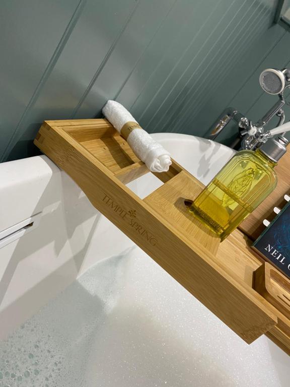 a bottle of wine on a wooden tray on a bathroom sink at Harbour Heights Whitby in Whitby