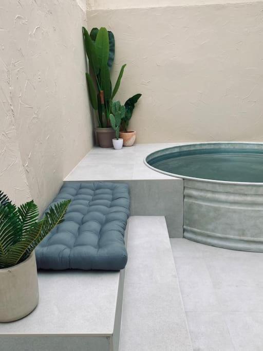 a blue ottoman sitting next to a tub with plants at Emuna House A Coruña in A Coruña