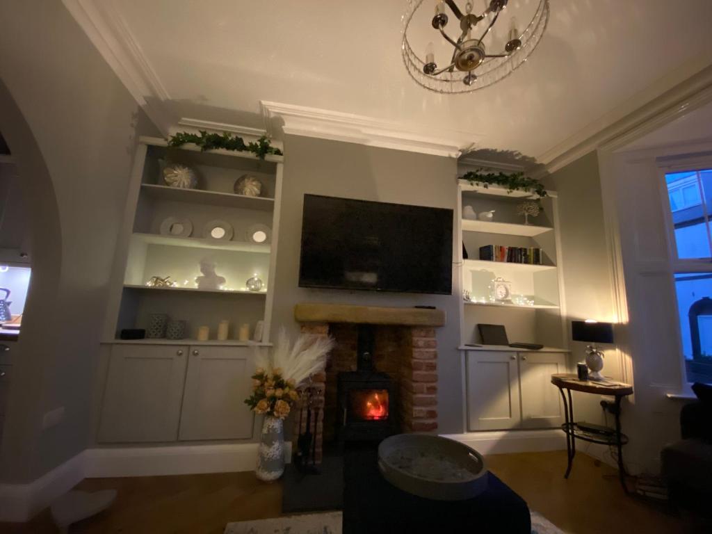 a living room with a fireplace and a flat screen tv at Harbour Heights Whitby in Whitby
