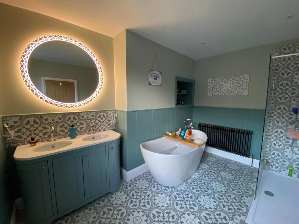 a bathroom with a tub and a sink and a mirror at Harbour Heights Whitby in Whitby