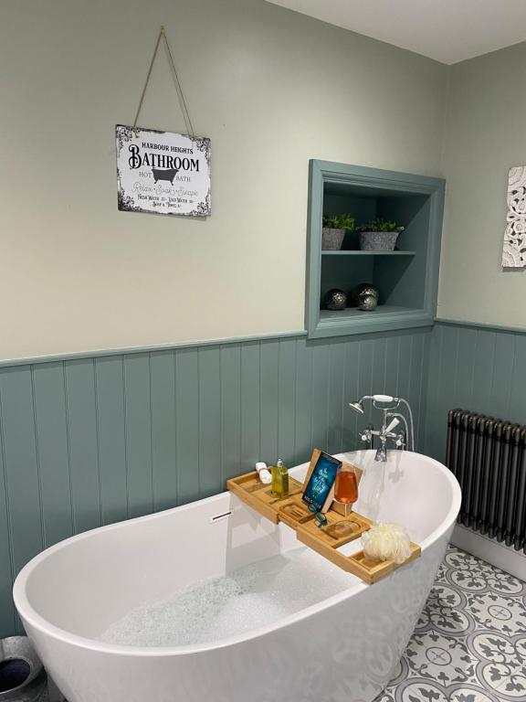 a bath tub with a wooden tray on it in a bathroom at Harbour Heights Whitby in Whitby