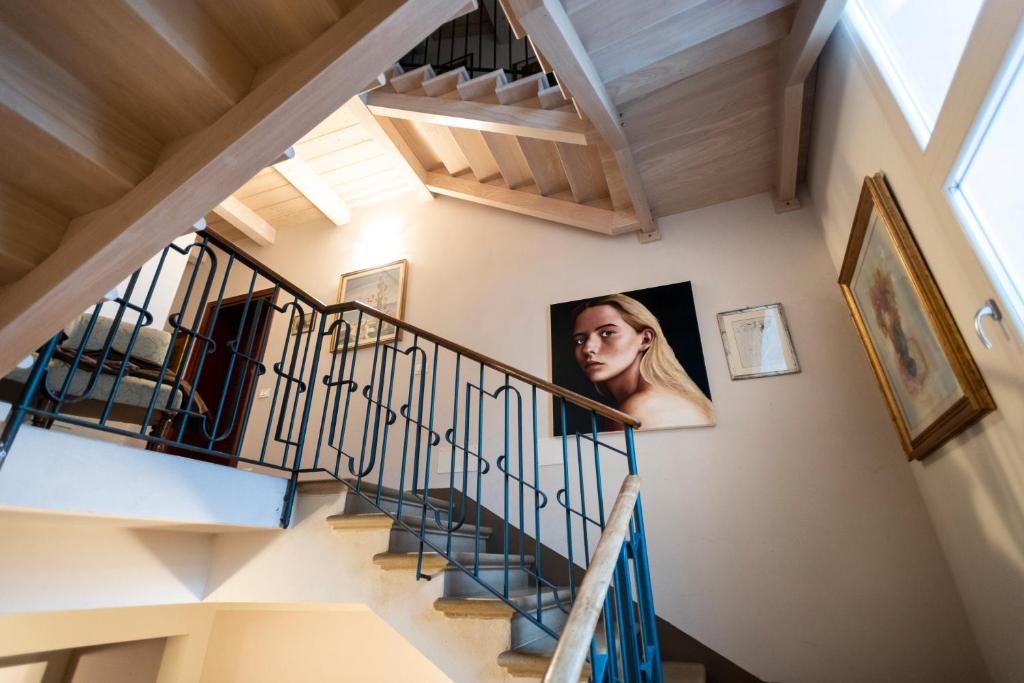 Una donna in piedi sulle scale di una casa di Al Battistero Luxury Suite a Ravenna