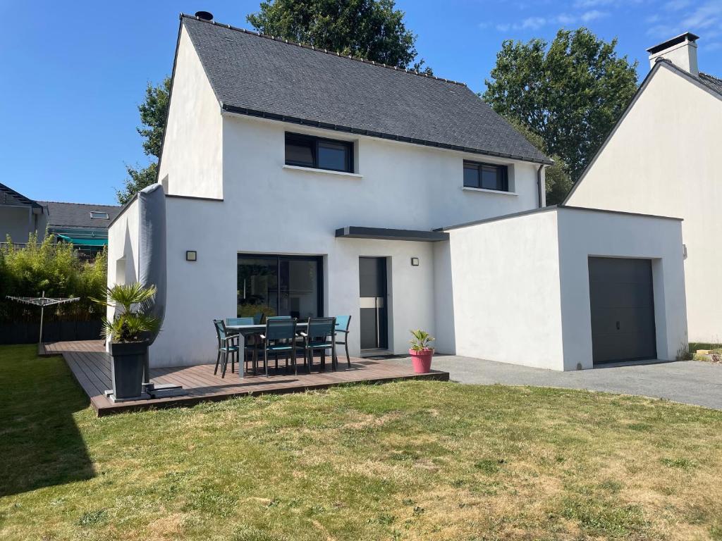 une maison blanche avec une table et des chaises sur une terrasse dans l'établissement Maison 4ch/8pers Bourg de Baden, à Baden