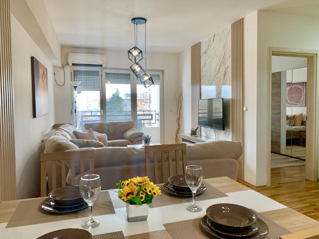 a dining room and living room with a table and chairs at Lux Apartment Dolce Casa Skopje Karpos IV in Dolno Nerezi