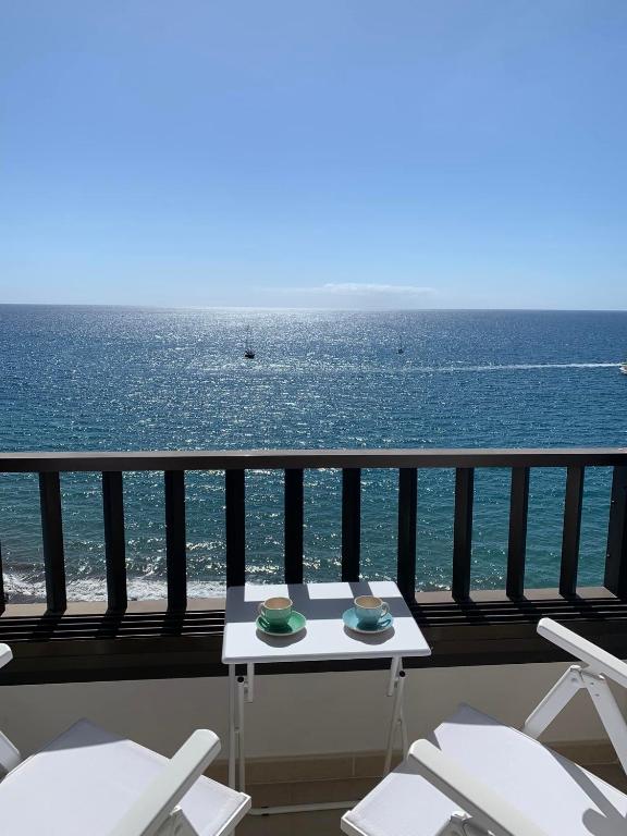 a table and chairs on a balcony overlooking the ocean at Sol y Sea Holiday Homes Don Paco in Patalavaca