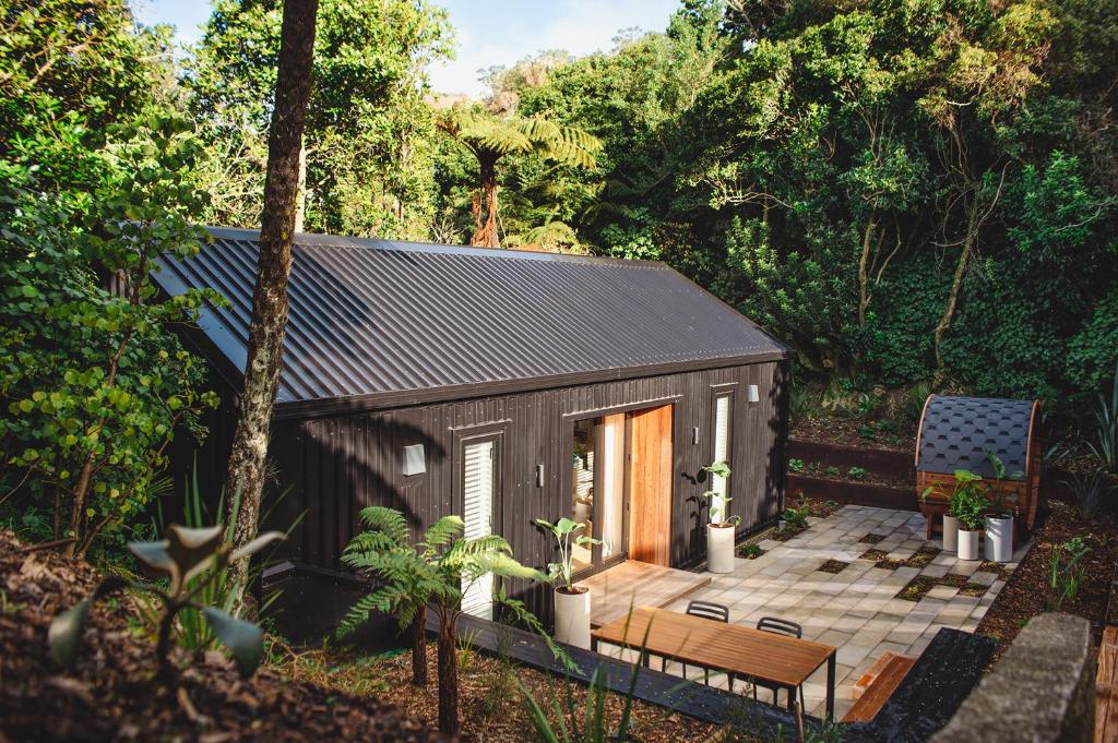 un pequeño cobertizo con una mesa y un banco en Urban oasis with sauna en Wellington