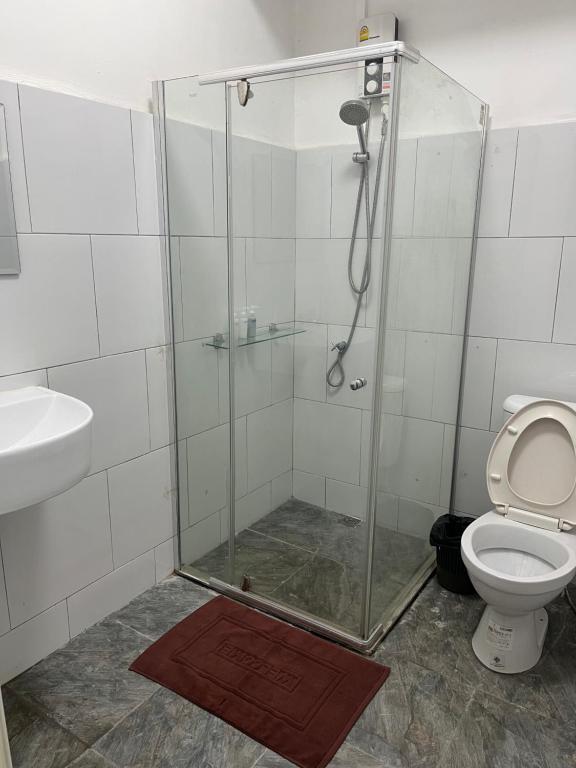 y baño con ducha, aseo y lavamanos. en Jidjai hostel en Chiang Rai