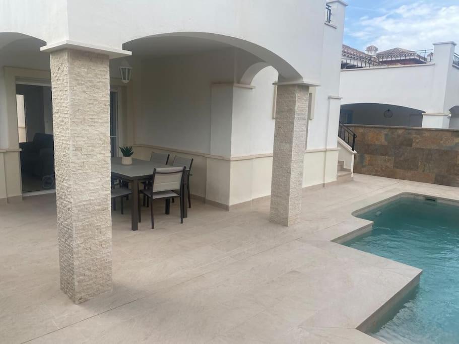 a patio with a table and a swimming pool at Villa Jacaranda in Torre-Pacheco
