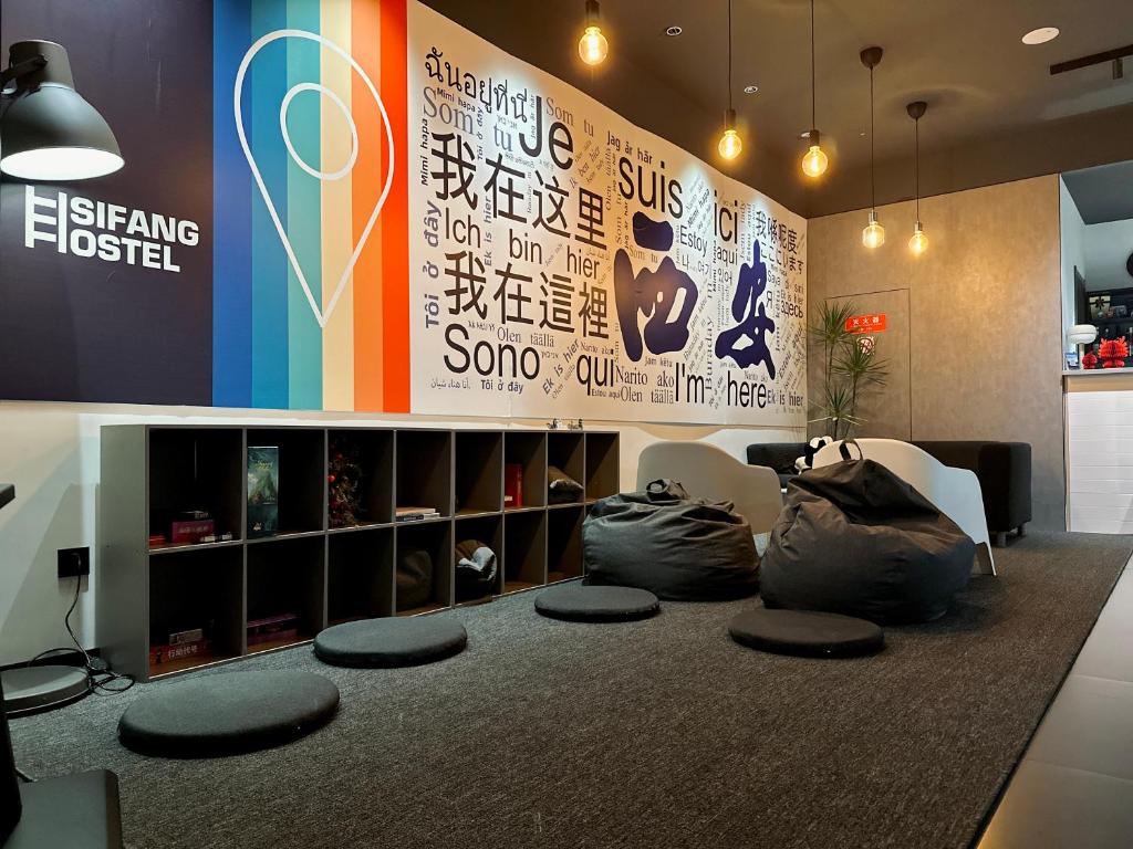 ein Wohnzimmer mit Sitzsäcken und einer Wand in der Unterkunft Sifang Space Hostel Xi'an - Xi'an KEJIDAXUE metro Line4 in Xi'an