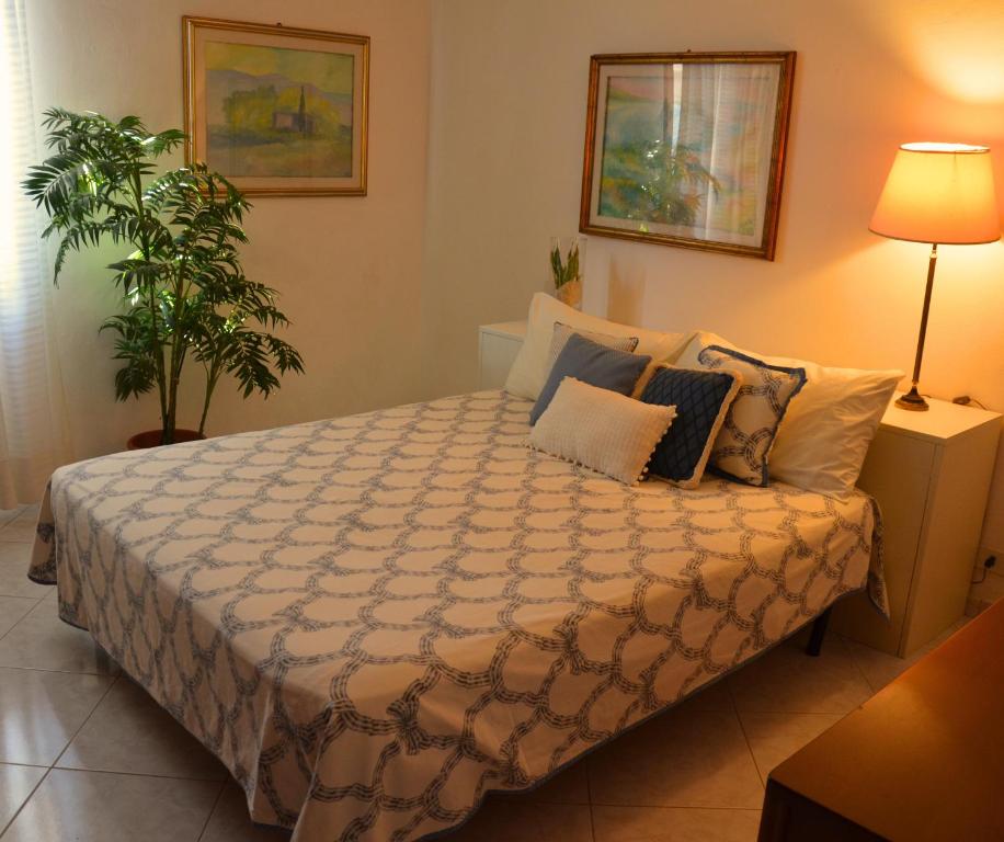 Un dormitorio con una cama con almohadas y una planta en Villa Noemi, en Scarlino