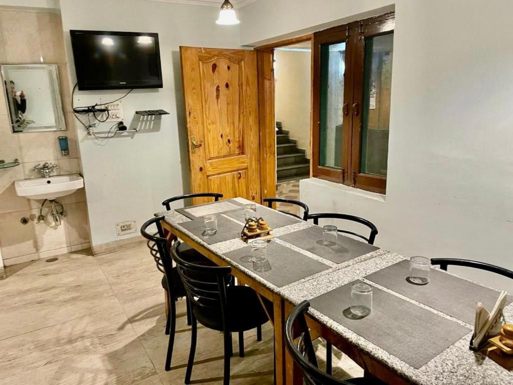 a dining room with a table and chairs and a television at Hotel Town Centre , Srinagar in Srinagar