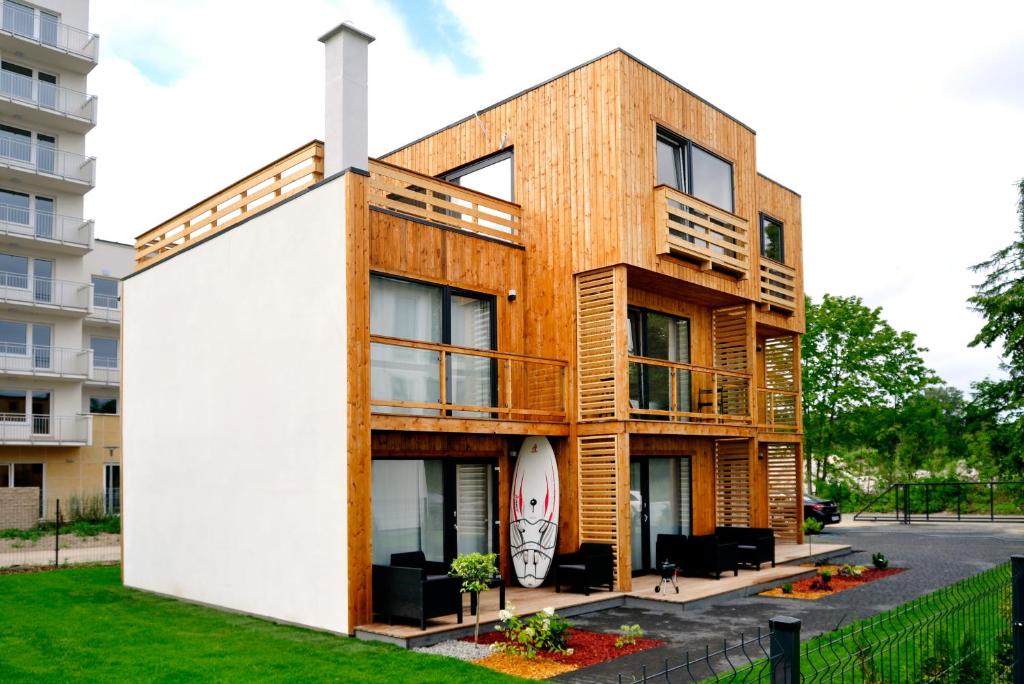 a wooden building with a white wall at RESET Mielno in Mielno