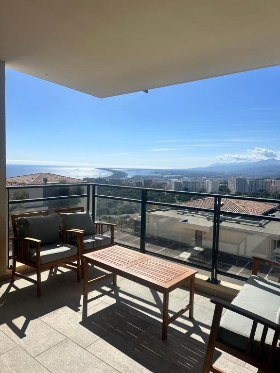 un balcon avec une table et des chaises et une vue dans l'établissement Vue panoramique Mer montagne Bastia, à Bastia