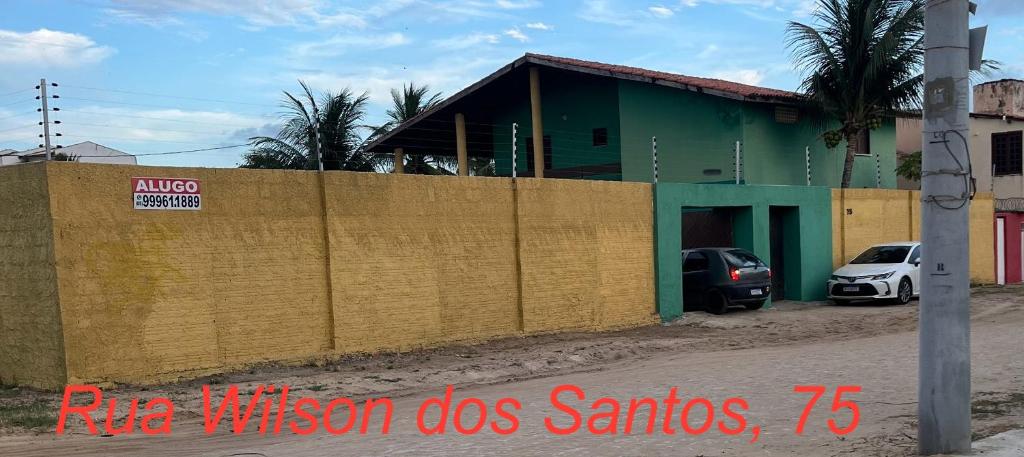 uma cerca em frente a um edifício com um carro em Casa de Praia na Tabuba-Ceará em Caucaia