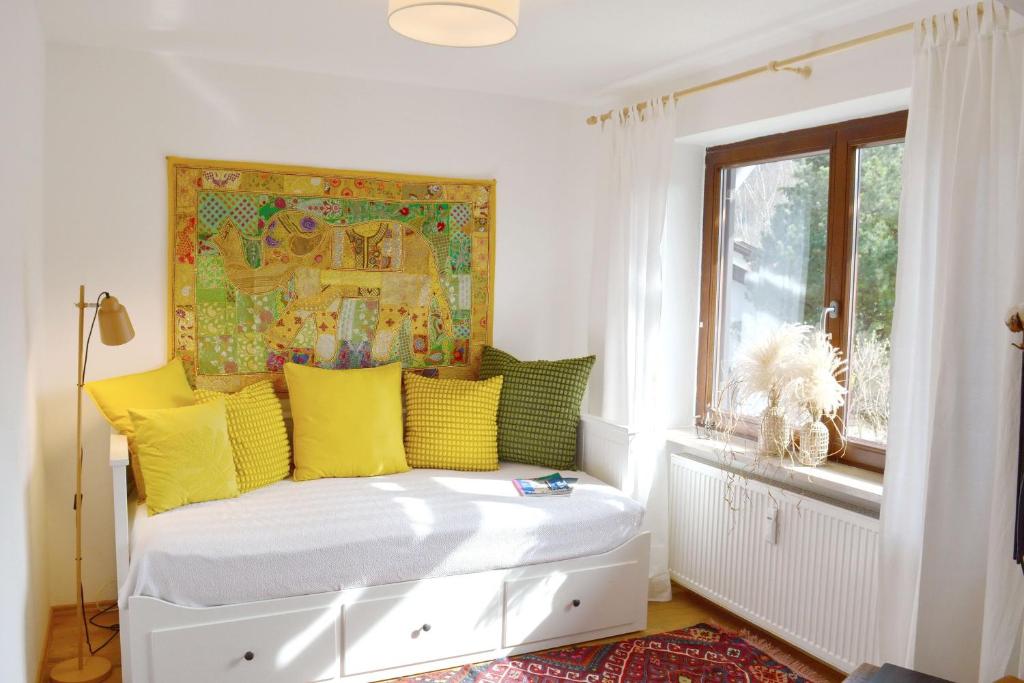 een kamer met een bed met gele kussens en een raam bij Zillibilly in Aschau im Chiemgau