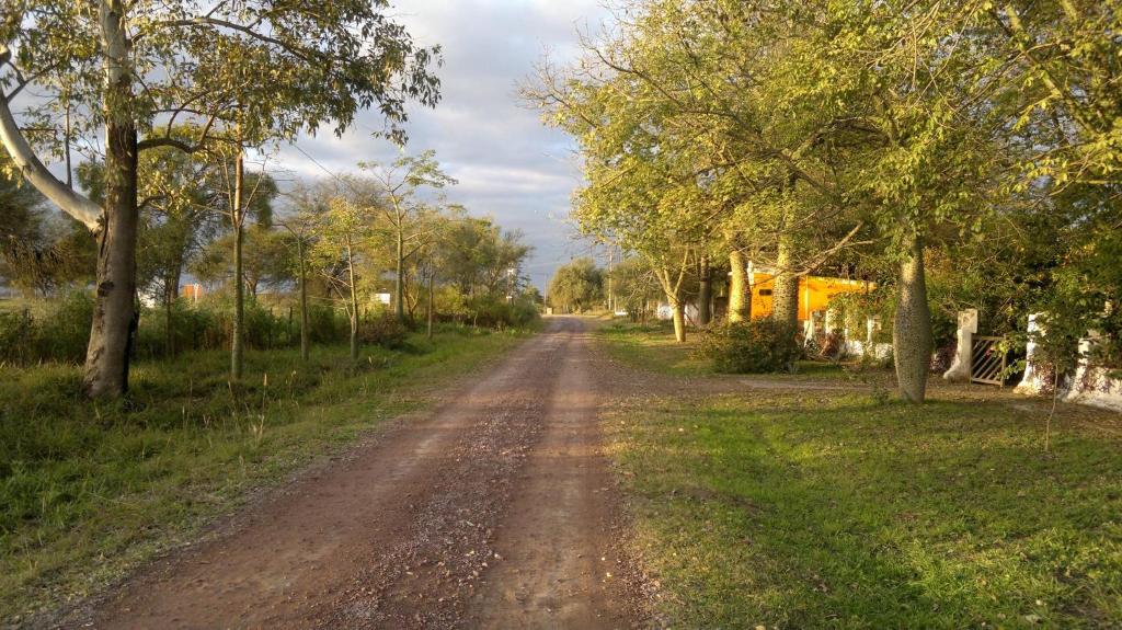 un camino de tierra con árboles a ambos lados. en Cabaña el rincón de Termas en Termas de Río Hondo