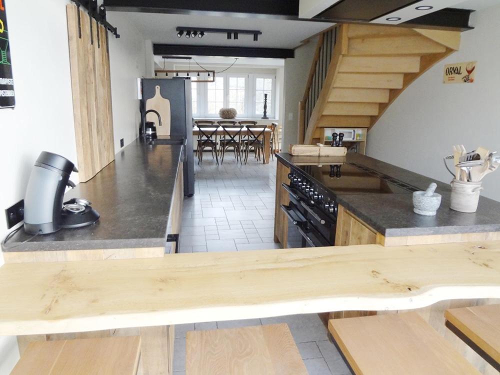 a large kitchen with wooden counter tops and a dining room at Le Repos du Clocher in Daverdisse