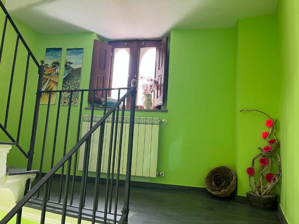 Habitación verde con escalera y ventana en Le Terrazze Sul Pollino B&B, en Civita