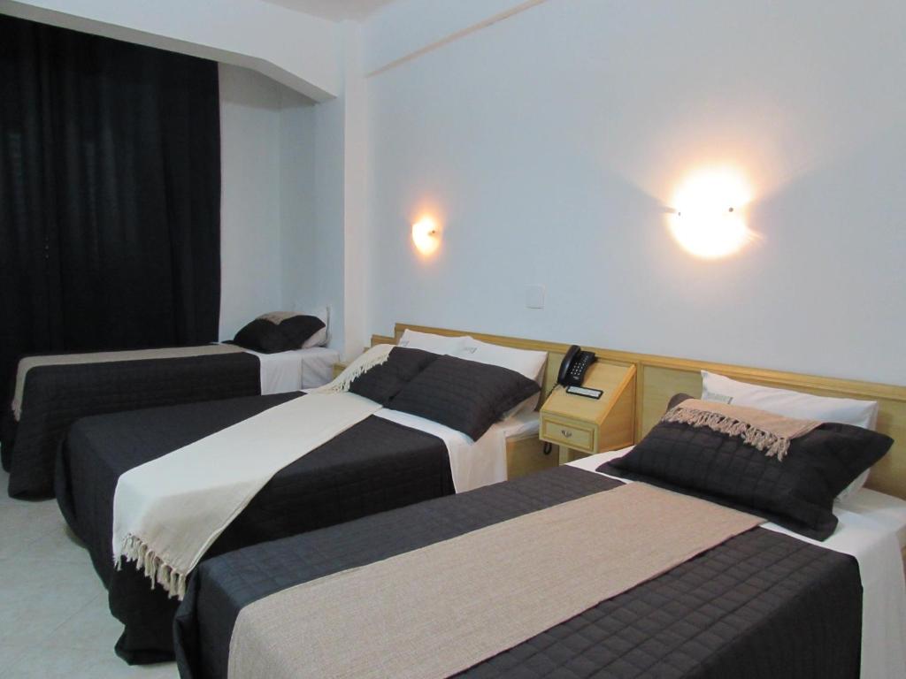 una habitación de hotel con 3 camas en una habitación en Hotel Paramount - São Paulo - Próximo a 25 de Março, Brás e Bom Retiro "Garanta já sua hospedagem", en São Paulo