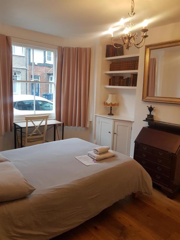 een slaapkamer met een bed, een bureau en een raam bij One Home in Oxford