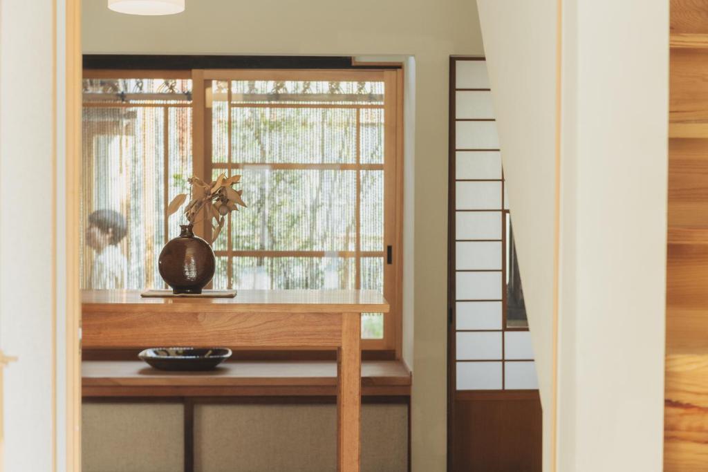 Zimmer mit einem Fenster mit einer Vase auf einem Tisch in der Unterkunft Une stay&diner in Sasayama