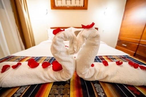 ein Paar weiße Socken auf einem Bett mit Herzen in der Unterkunft tourist house suites 2 in Otavalo