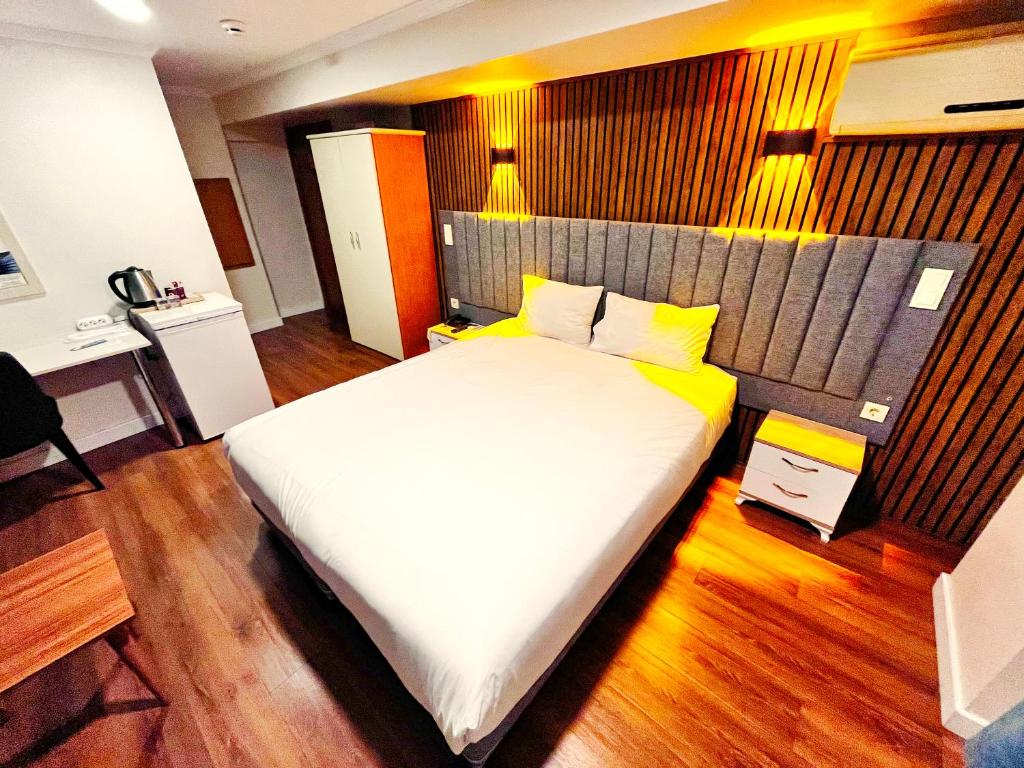 イスタンブールにあるNaila Hotelのベッドルーム1室(白い大型ベッド1台付)