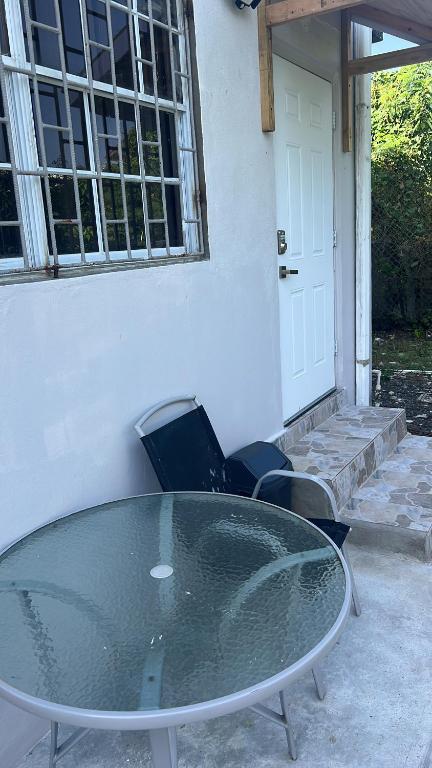 a glass table and chairs in front of a house at Dream Stay Studio 2 in Vieux Fort