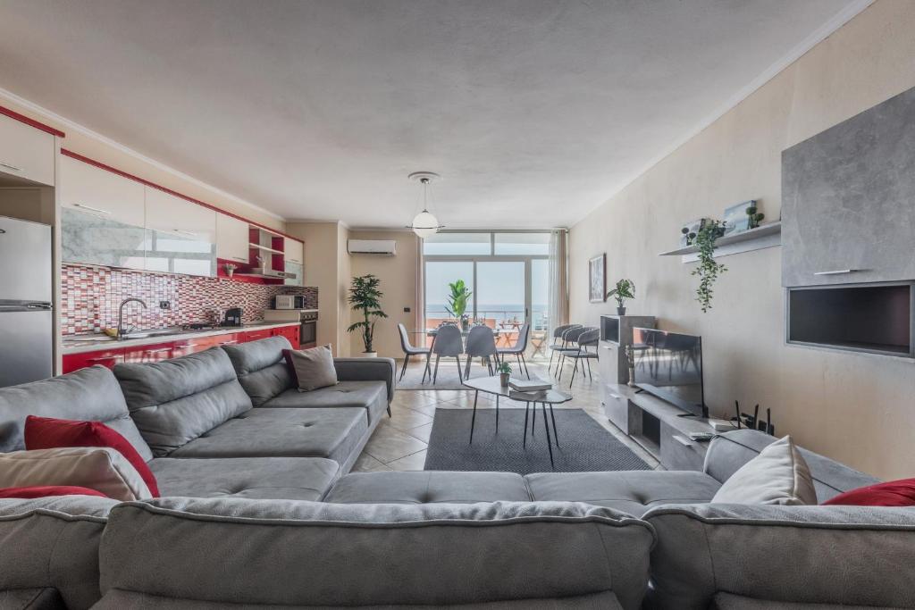 a living room with a couch and a tv at Three Bedroom Romantic Promenade Apartment in Durrës