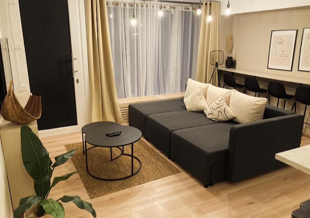 a living room with a black couch and a table at City-Apartment Kreuzviertel-Lädchen mit gratis Parkplatz in Münster