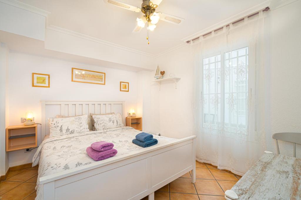 1 dormitorio con 1 cama con 2 toallas en Casita del Puerto 1 en Santa Pola