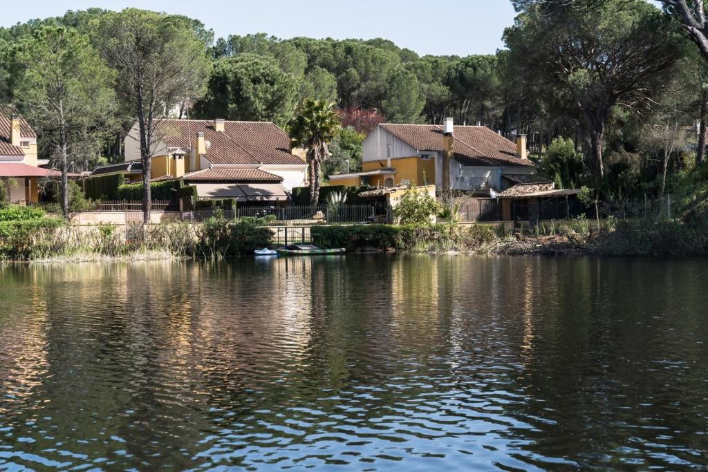 Casa El Lago Alojamiento Rural في Las Jaras: مجموعة منازل بجانب تجمع مياه