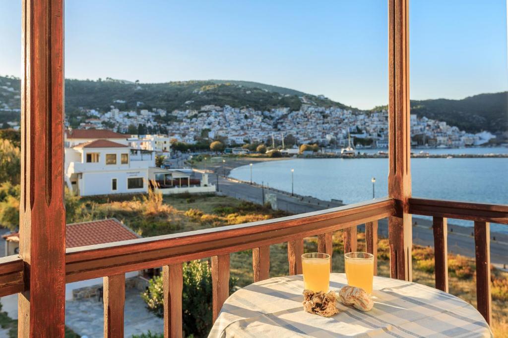 2 bicchieri di succo d'arancia seduti su un tavolo sul balcone di Nikolaos studios apartments a Skopelos Town