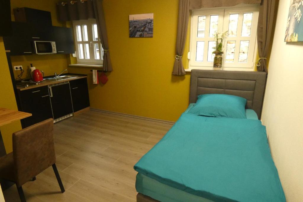a small bedroom with a bed and a kitchen at Tessin in Schwandorf in Bayern