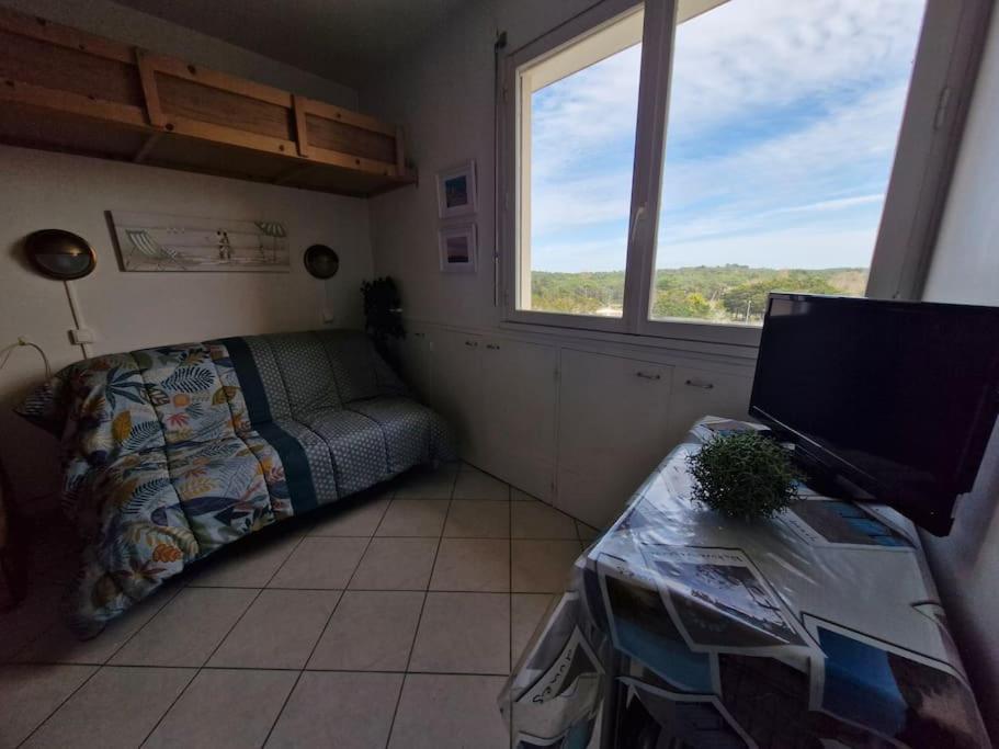 Schlafzimmer mit einem Bett und einem Schreibtisch mit einem TV in der Unterkunft Studio - Marina 4 - 17 allée des Pinons - 5-4 in Saint-Jean-de-Monts