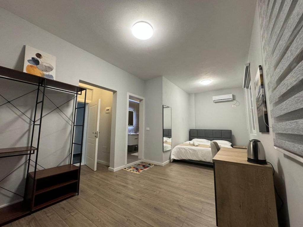 a room with a bedroom with a bed and a mirror at AVENUE Apartment 02 Tirana in Tirana