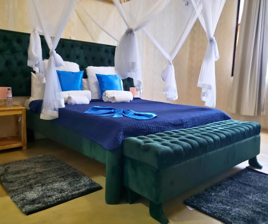 Un dormitorio con una cama azul con gafas azules. en Galo do Mar en Maputo
