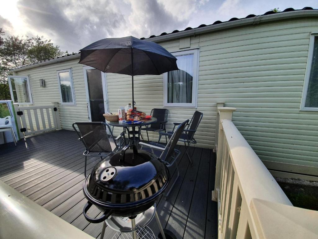 a patio with a table and an umbrella on a deck at 22 Washbrook Way in Ashbourne