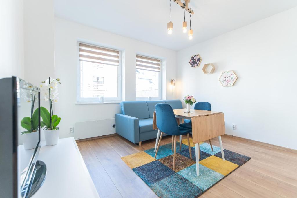 Apartament w Centrum في مينززدرويه: غرفة معيشة مع طاولة وأريكة زرقاء