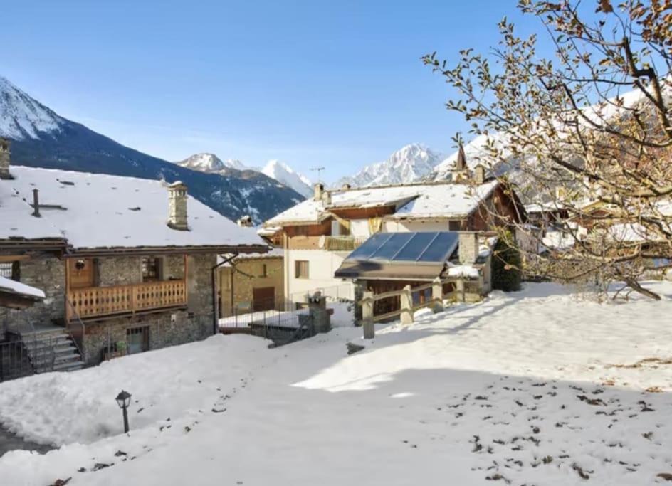 a house in the snow with mountains in the background at Chalet vista Monte Bianco in La Salle