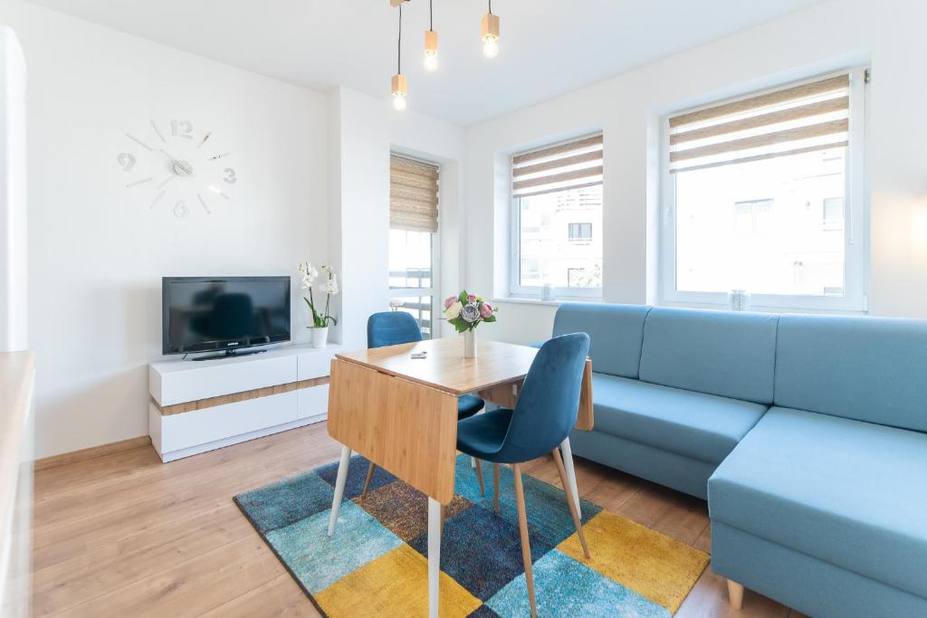 a living room with a blue couch and a table at Apartament w Centrum in Międzyzdroje